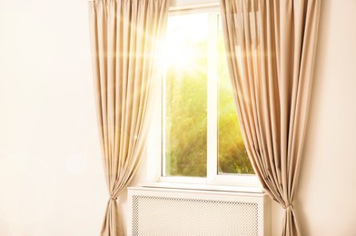 Bright sun shining through window with stylish curtains