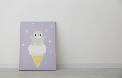 Adorable picture of penguin and ice cream on floor near white wall, space for text. Children's room interior element