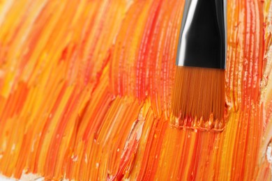 Photo of Applying colorful oil paints with brush on canvas, closeup