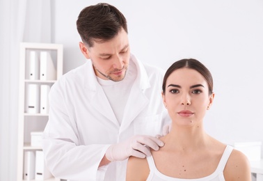 Doctor examining patient in clinic. Visiting dermatologist