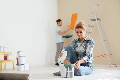 Happy couple painting wall indoors. Home repair