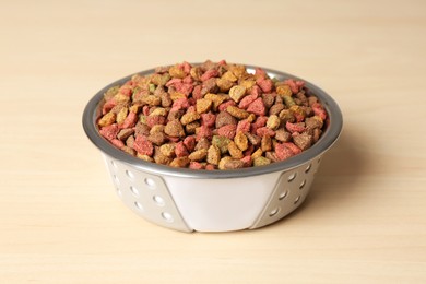 Photo of Dry dog food in pet bowl on wooden surface