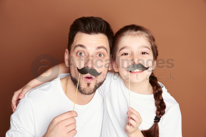Dad and his daughter having fun on color background. Father's day celebration