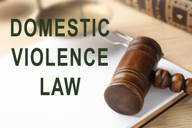 Clipboard and gavel on wooden table. Domestic violence law concept