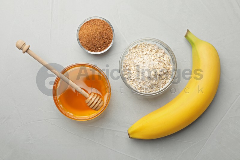 Different ingredients for handmade face mask on grey stone background, flat lay