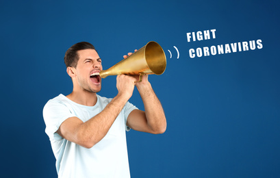 Handsome man with megaphone on blue background. Fighting with coronavirus