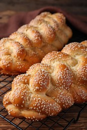 Homemade braided breads with sesame seeds on wooden table, closeup. Challah for Shabbat