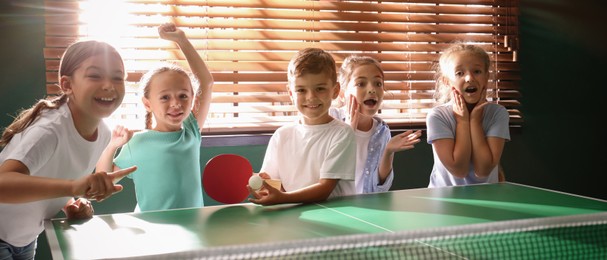 Cute happy children playing ping pong indoors. Banner design