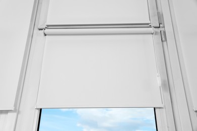 Window with white roller blinds, closeup view