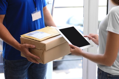 Woman using app to confirm delivery of parcel from courier on doorstep, closeup