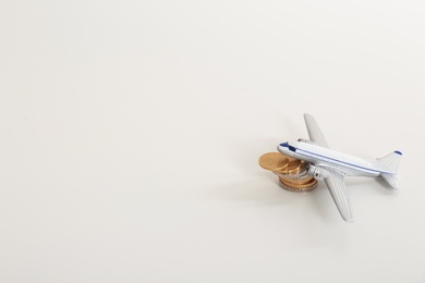 Toy plane, coins and space for text on white background. Travel insurance