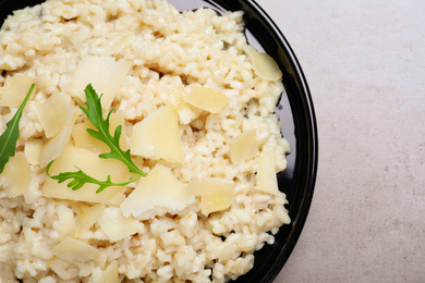 Photo of Delicious risotto with cheese on grey table, top view