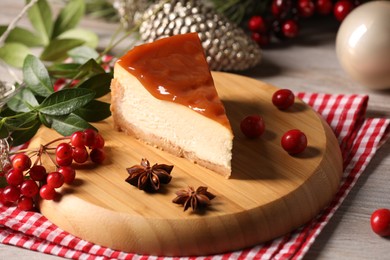 Photo of Tasty caramel cheesecake and Christmas decorations on wooden table