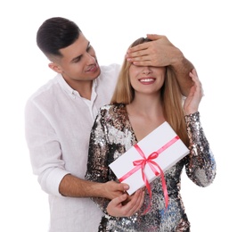 Man surprising his girlfriend with gift on white background. Valentine's day celebration