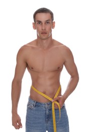 Handsome shirtless man with slim body and measuring tape around his waist isolated on white