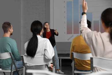 Female business trainer giving lecture in conference room with projection screen