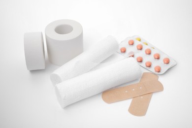 Bandage rolls and medical supplies on white background