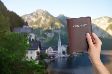 Woman with passport and beautiful view of town near mountains on background