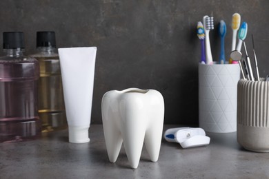 Tooth model and oral care products on grey table