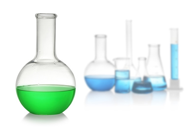 Florence flask with green liquid near laboratory glassware on white background