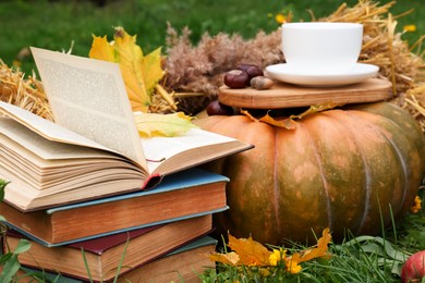 Books, pumpkin and cup of tea outdoors. Autumn season