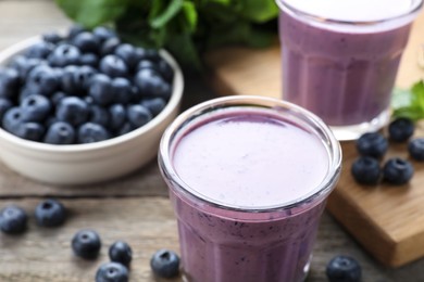 Freshly made blueberry smoothie on wooden table, closeup