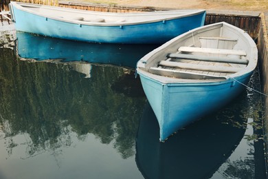 Light blue wooden boats on river, space for text