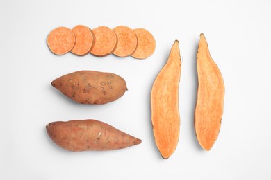 Cut and whole sweet potatoes on white background, top view