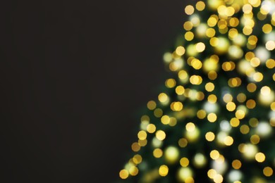 Blurred view of beautifully decorated Christmas tree on brown background, space for text