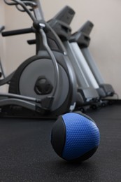 Photo of Blue medicine ball on floor in gym, space for text