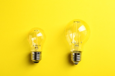 Vintage filament lamp bulbs on yellow background, top view