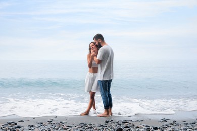 Happy young couple on beach near sea