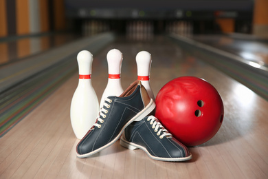 Shoes, pins and ball on bowling lane in club