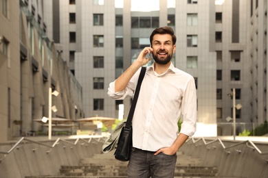 Handsome man talking on phone in modern city