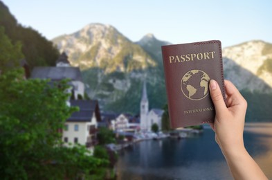 Woman with international passport and beautiful view of town near mountains on background