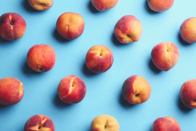 Fresh ripe peaches on light blue background, flat lay