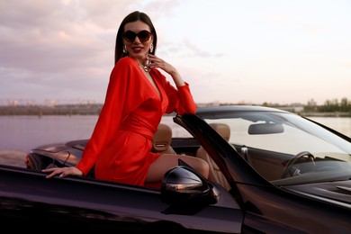 Photo of Sexy woman in luxury convertible car outdoors