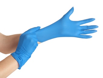Woman putting on blue latex gloves against white background, closeup of hands