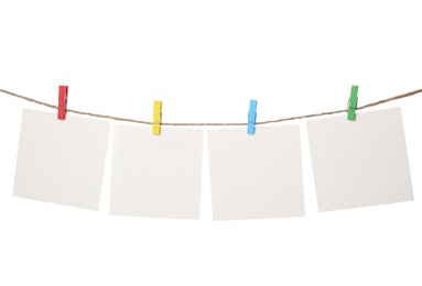 Clothespins with empty notepapers on string against white background. Space for text