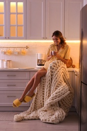 Beautiful young woman enjoying coffee in kitchen. Weekend morning