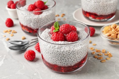 Delicious chia pudding with raspberries and mint on light marble table