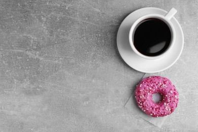 Photo of Tasty frosted donut and cup of coffee on light grey table, flat lay. Space for text