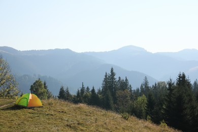 Picturesque view of camping tent in mountains. Space for text
