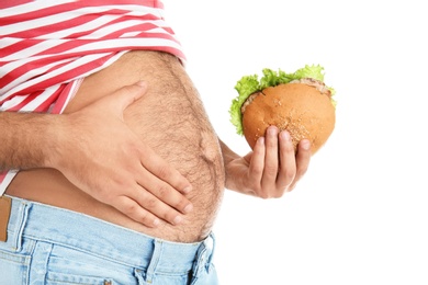 Overweight man with hamburger on white background, closeup