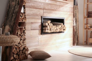 Decorative fireplace with stacked wood in cozy living room interior