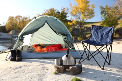 Camping equipment near tent with sleeping bag outdoors