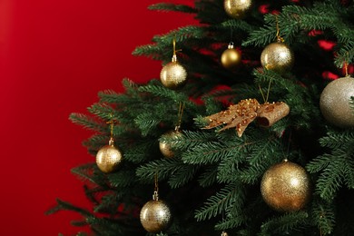 Beautifully decorated Christmas tree on red background, closeup