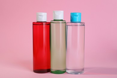 Bottles of micellar water on pink background