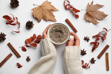 Photo of Woman with cup of hot drink on white background, top view. Cozy autumn atmosphere