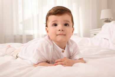 Cute baby boy on bed at home